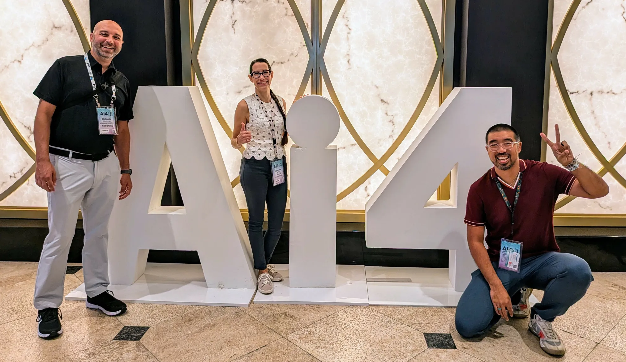 Michael, Becka, and Garvin posing with a large Ai4 sign